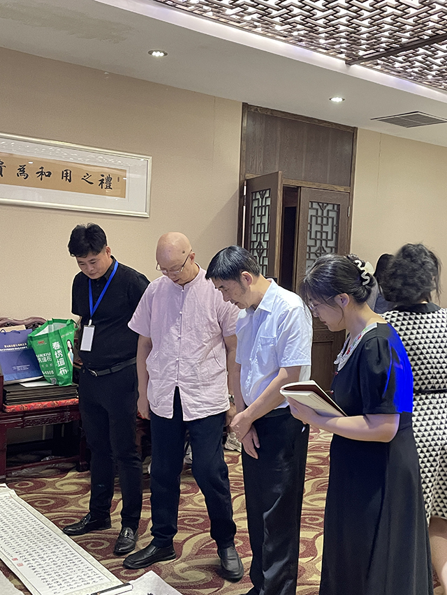 华夏国艺书画艺术中心副主任、中国书画家联谊会新文艺群体书画家工作委员会理事、中企报盟信息科学研究院副院长刘小龙携学生、华夏国艺书画艺术中心会员张春根与中国文联办公厅主任、中国民族建筑研究会书画艺术专业委员会主任罗杨欣赏书法作品.jpg