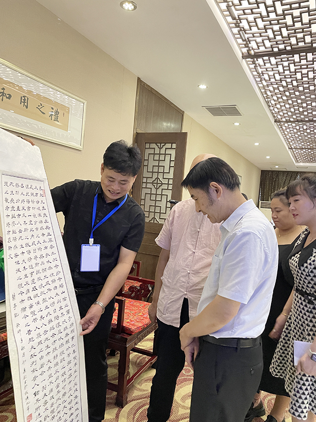 华夏国艺书画艺术中心副主任、中国书画家联谊会新文艺群体书画家工作委员会理事、中企报盟信息科学研究院副院长刘小龙与中国文联办公厅主任、中国民族建筑研究会书画艺术专业委员会主任罗杨欣赏并点评华夏国艺书画艺术中心会员张春根创作的书法作品.jpg
