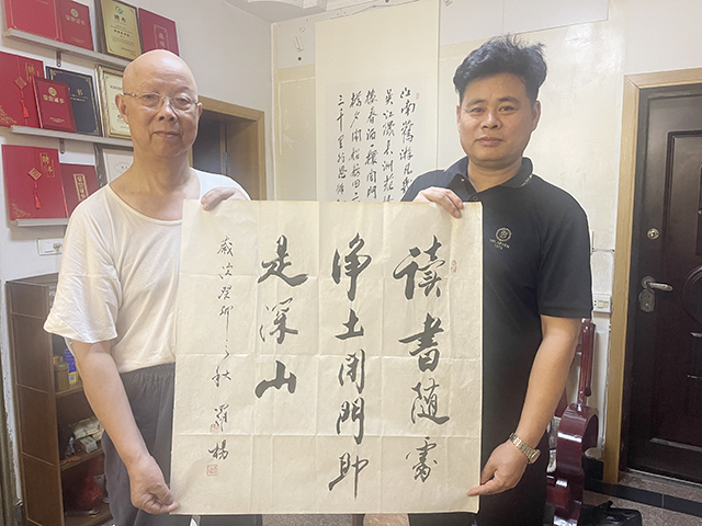 华夏国艺书画艺术中心会员、中企报盟信息科学研究院研究员张春根和恩师华夏国艺书画艺术中心副主任、中国书画家联谊会新文艺群体书画家工作委员会理事、中企报盟信息科学研究院副院长刘小龙与中国文联办公厅主任、中国民族建筑研究会书画艺术专业委员会主任罗杨书法作品合影.jpg