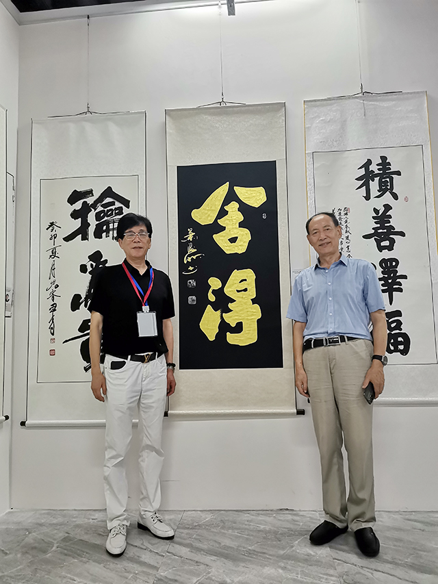 权希军入室弟子、中华英才融媒体中心联盟理事会副理事长、中国书画家联谊会新文艺群体书画家工作委员会理事兼副秘书长左继君与中国书法家协会会员、中国民族建筑研究会书画艺术专业委员会理事会副主席肖海明在孔子博物馆展览现场合影.jpg