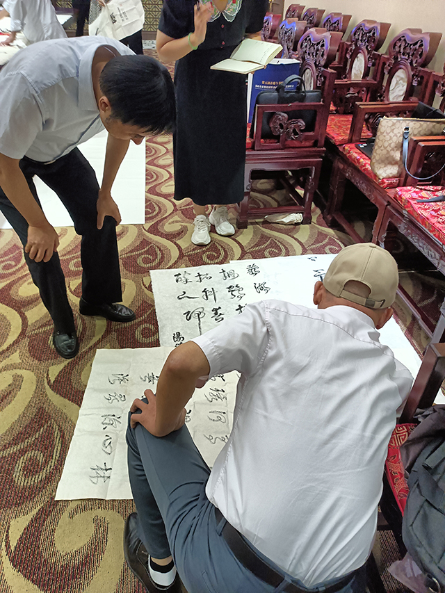 中国文联办公厅主任、中国民族建筑研究会书画艺术专业委员会主任罗杨给汤主任现场作品点评.jpg