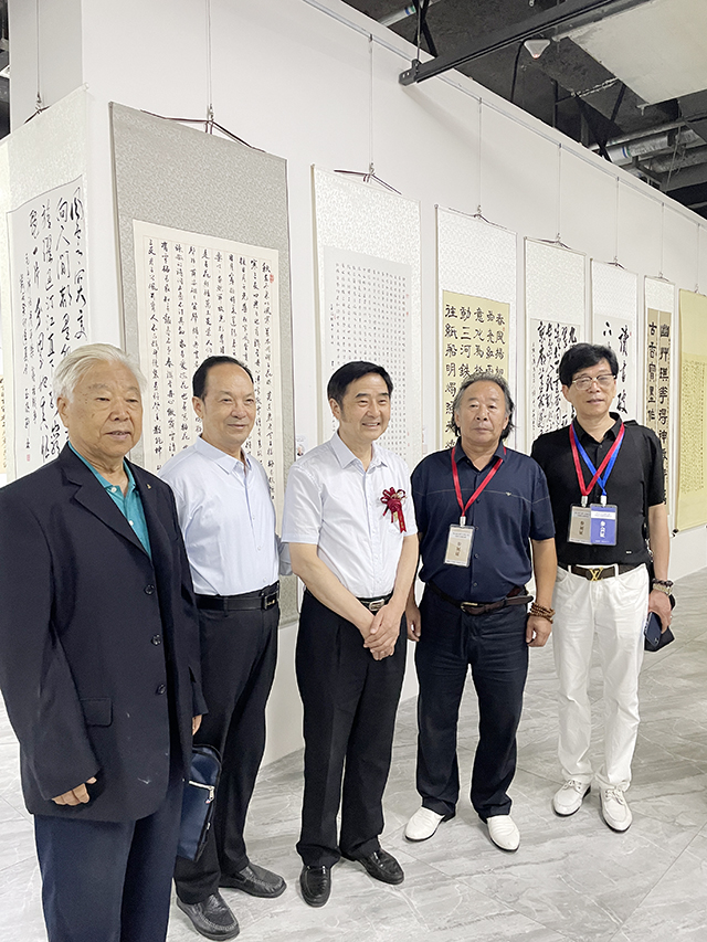 中国文联原办公厅主任、中国老年书画研究会会长、中国民族建筑研究会书画艺术专业委员会主任罗杨和参展艺术老师在作品前合影.jpg