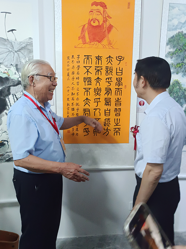 颜真卿书画院院长暨研究院执行院长魏宝玉和中国文联办公厅主任、中国民族建筑研究会书画艺术专业委员会主任罗杨在作品前交流.jpg