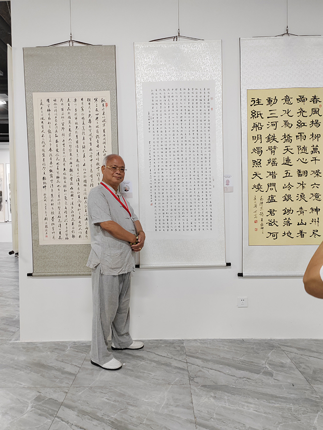 央广文旅发展中心副理事长、中国楹联学会书法艺术研究会常务理事林文亮在作品前拍照留念.jpg